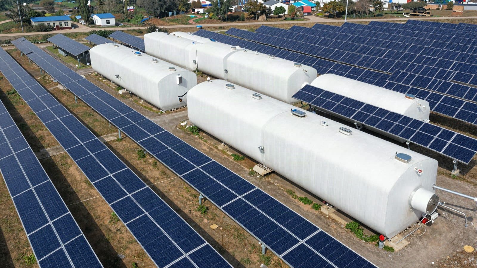 Aerial view of a solar park with a row of battery containers